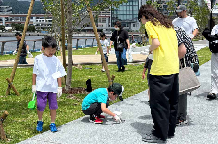 フェリシモ本社(神戸市)近くの海沿いを歩いてゴミ拾いをする子供たち