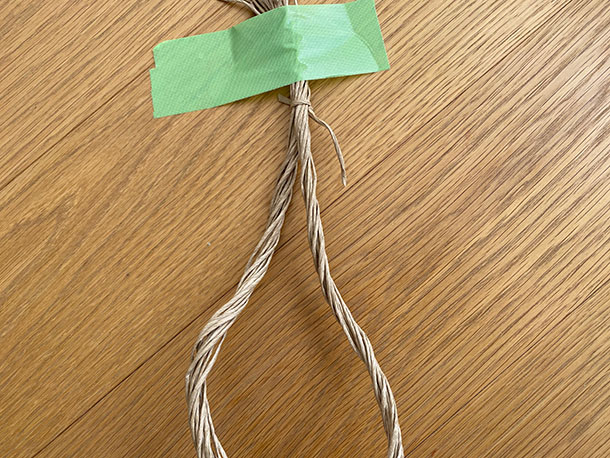 束ねたひもを真ん中でふたつに分け、それぞれをねじります。