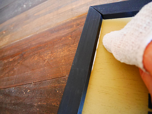 角材をベニヤ板にはめてはみ出た木工用接着剤をぬらしたウエスなどでふき取ります