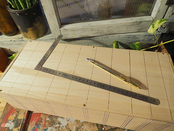 まず、木箱の背面に5cm間隔で縦線を引いていきます。きっちり測っていないのですが最後の３つくらいで5cmより幅が短くなるようにして微調整しています