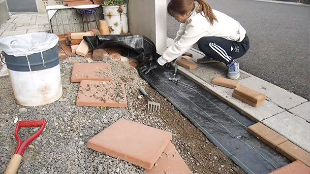 防草シートは専用のピンを地面に刺して固定する