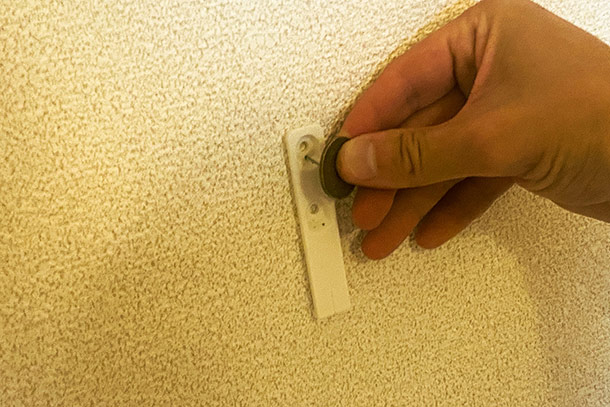 壁側の金具をコインを使ってくぎを打っていきます
