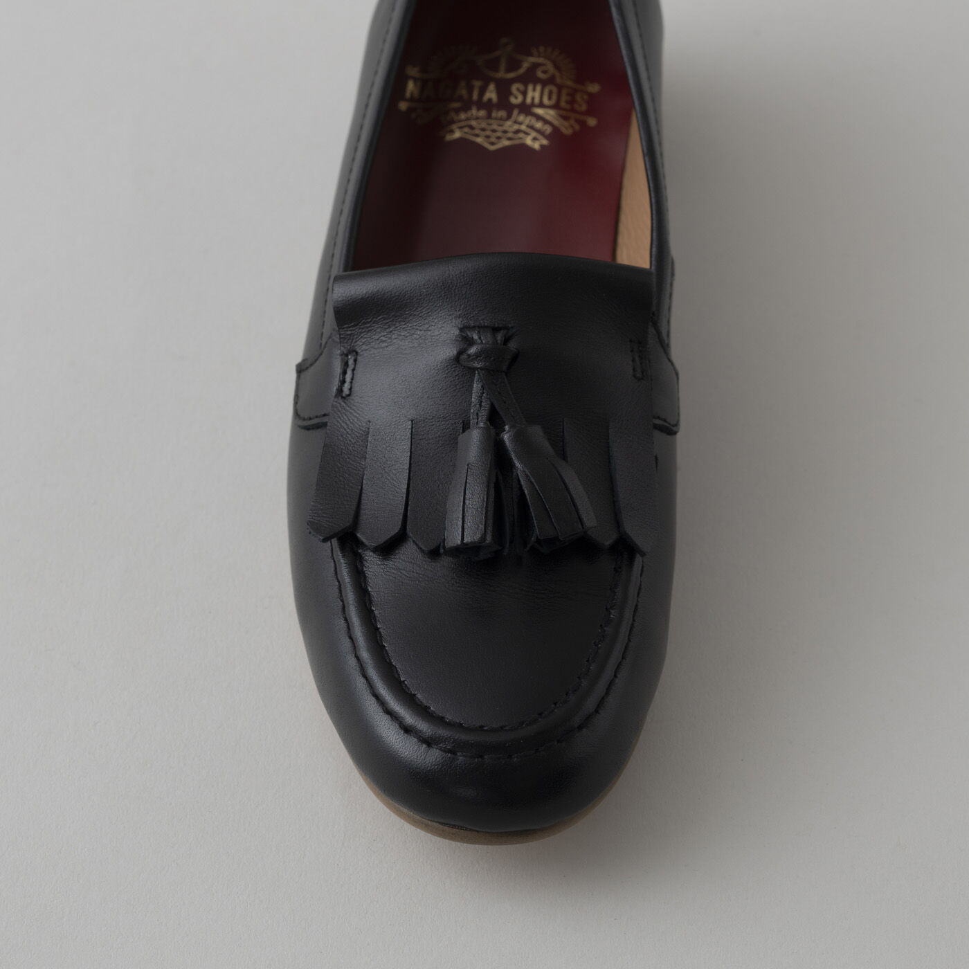 ＆Stories|長田の靴メーカーと作った　職人本革のタッセルローファー〈ブラック〉|甲部分（モカ）のステッチは、専用のミシンを使った本格仕様。ぷっくりとしたラインが美しいＵ字を描き、歩くたびに揺れるタッセルとともに愛らしい表情を添えます。