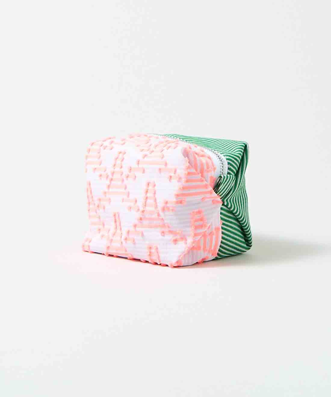 SeeMONO[シーモノ］|ジャカード織生地で作ったキャラメルみたいな形のポーチ〈ＰＩＮＫ　ＴＲＩＡＮＧＬＥ×ＧＲＥＥＮ　ＳＴＲＩＰＥ〉|透け感のある白と淡いピンクのボーダー地に並ぶ蛍光ピンクのタワーのような三角形と、グリーンと白の斜めストライプのジャカード織生地。