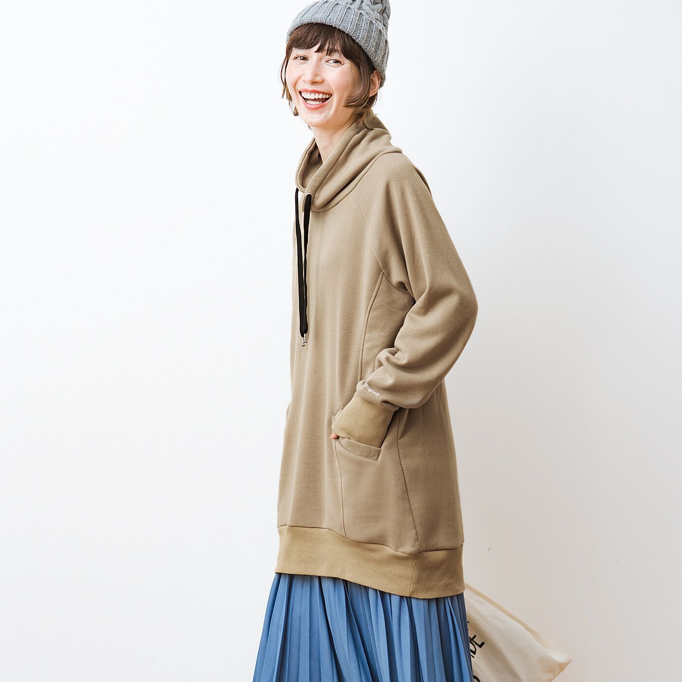 frauglatt|フラウグラット　大人気♪　首まであったかしあわせな着心地 大人のパーカー風ハイネック裏起毛チュニックの会|後ろすそがやや長めでヒップまですっぽりカバーする安心丈。プリーツスカートと合わせてロング＆リーンなシルエット。