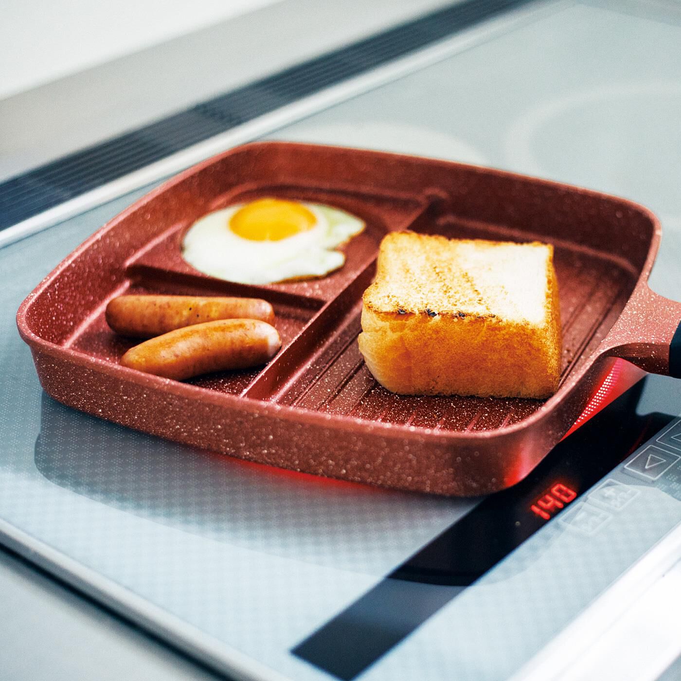 フェリシモギフトショップ|３つの料理が一度にできちゃう　仕切りフライパン|メインスペースは、食パン１枚やステーキが焼けるワイド設計。余分な油を落としながら焼ける波型構造。