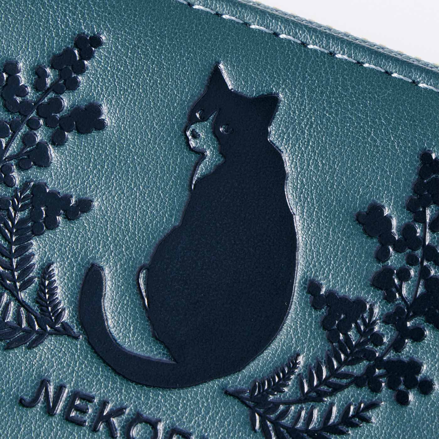 フェリシモギフトショップ|福を呼ぶハチワレ猫とミモザの型押し長財布|落ち着いたピーコックブルーの合皮素材に、ハチワレ猫とミモザの型押しが大人っぽい仕上がり。