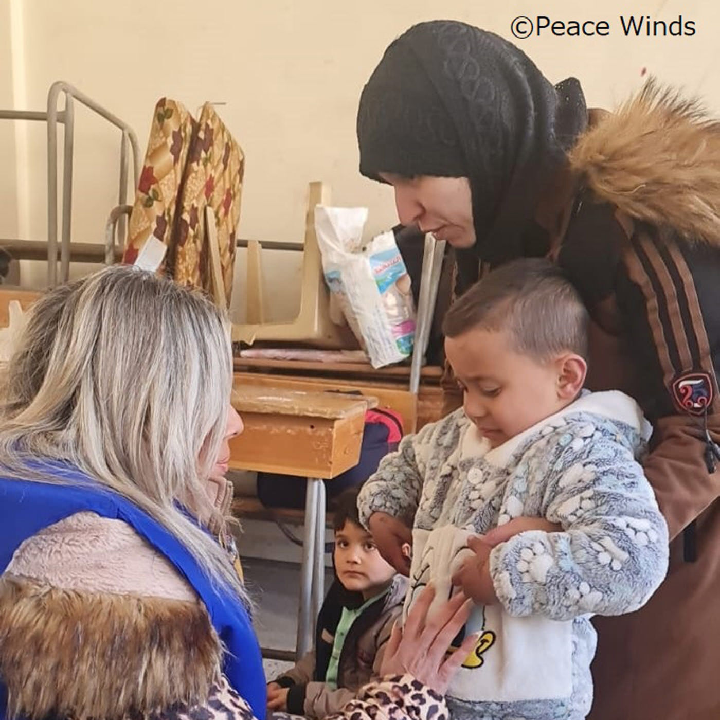 フェリシモの雑貨Kraso|フェリシモ　地球村の基金|(C)ピースウィンズ・ジャパン　避難場所の子どもに寄りそうスタッフ（シリア）