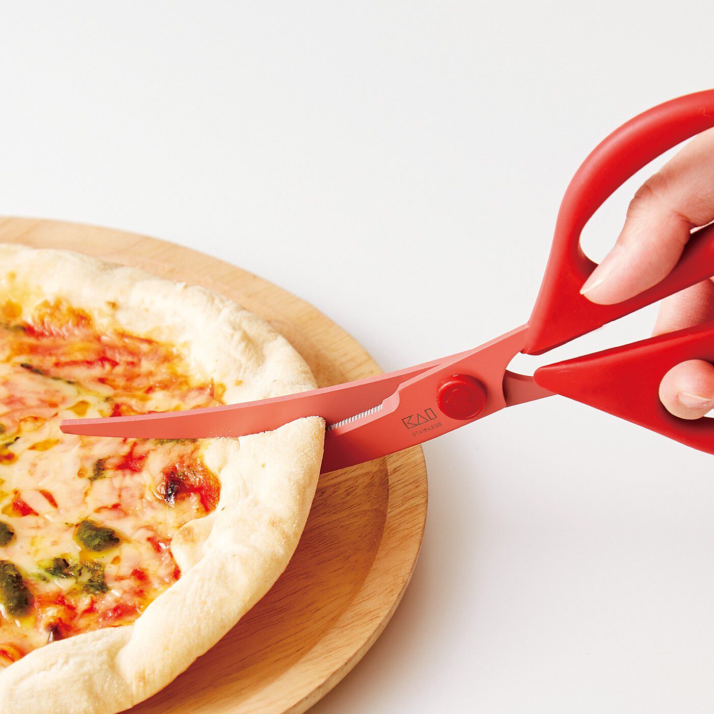 フェリシモの雑貨 Kraso|エスキューブキッチンズ　ギザギザ刃でお肉も野菜も　スムーズカット カーブキッチンばさみ|刃がカーブしているので、ピザもお皿の上でスムーズにカット。