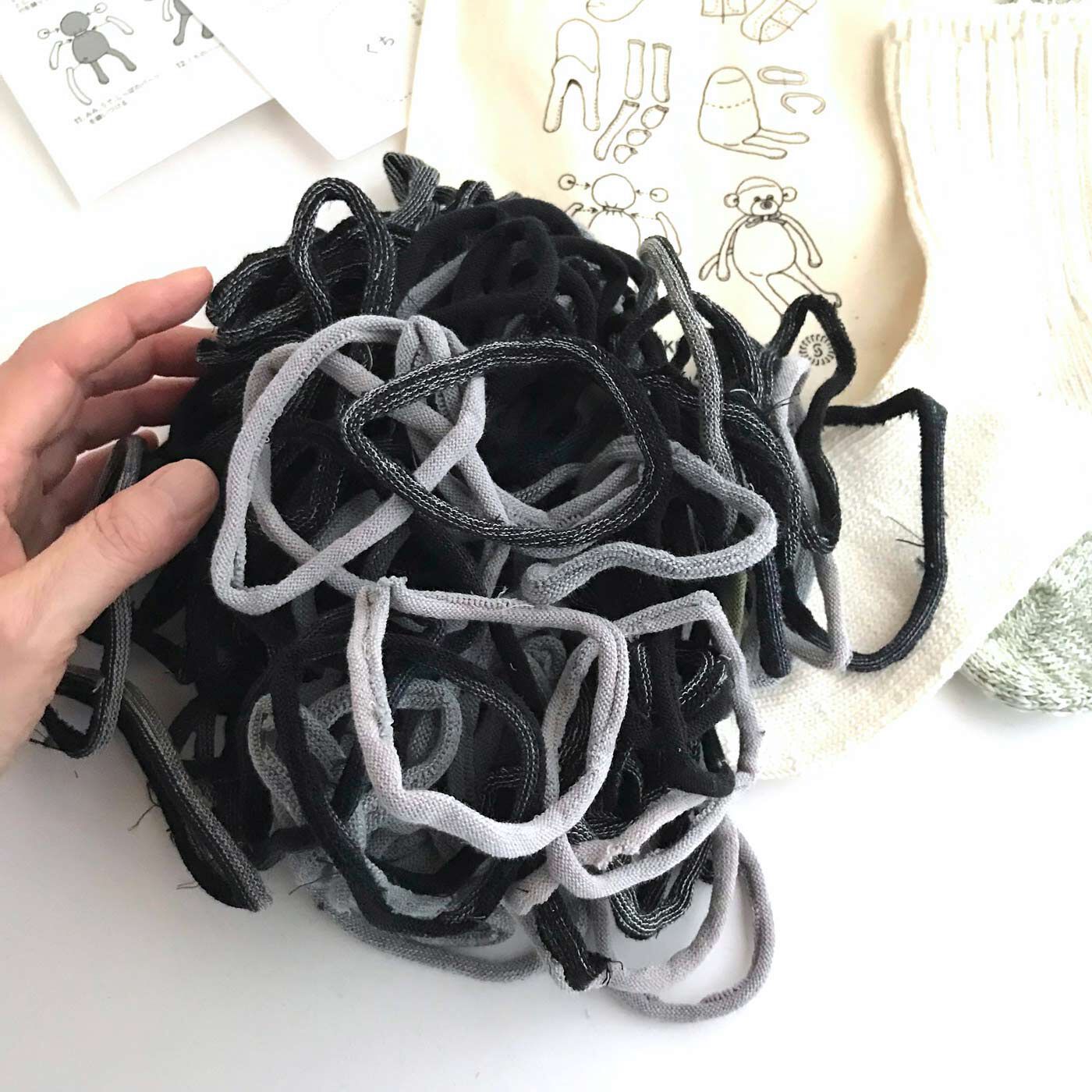フェリシモの雑貨Kraso|残糸で編んだ靴下と端材で作るおさるのぬいぐるみキット〈巾着付き〉|この輪っかは、靴下のつま先を縫製する際に切り取られる端材。おもしろい！