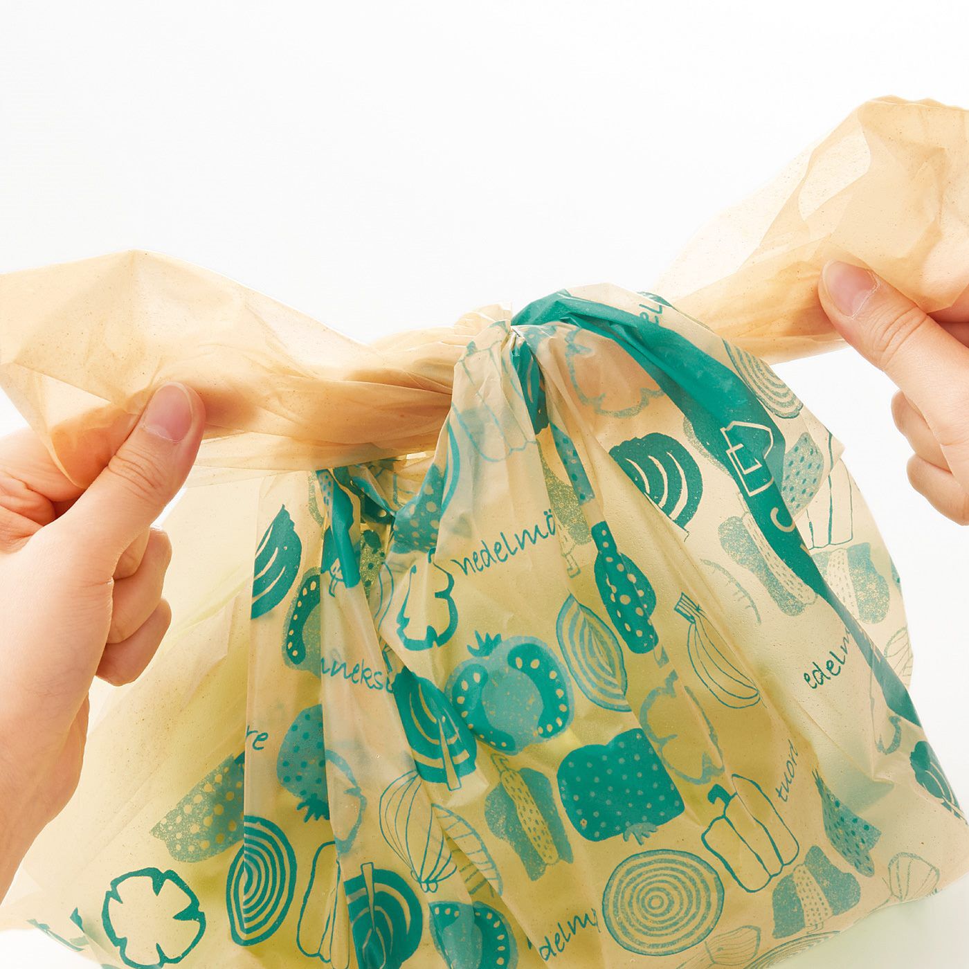 フェリシモの雑貨Kraso|野菜・くだものシャキッと長持ち！　米ぬかで抗菌 レジ袋みたいな鮮度保持バッグ〈Lサイズ〉の会|すき間がないようしっかり持ち手を結びます。