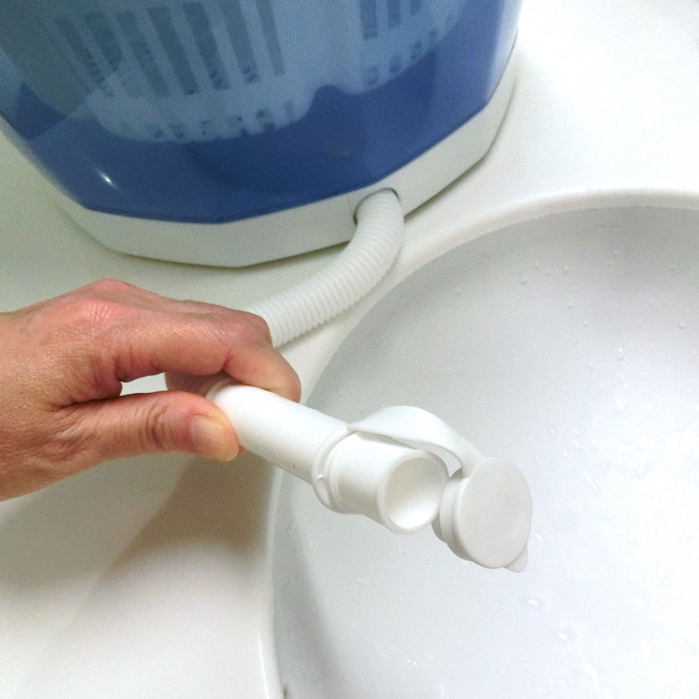 フェリシモの雑貨 Kraso|【大物配送】汚れ物の別洗いに　電気がなくても洗濯できる　手動洗濯&脱水機　エコスピンウォッシャー|本体に付いたホースから汚れた水を流した後、回すと脱水できます。