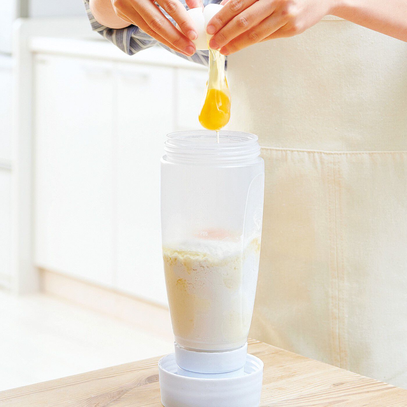 フェリシモの雑貨Kraso|キッチンも手も汚れない　粉もの調理らくちん ふりふりミキサー|〈How to use〉1．開けた底ふたにボトルを立てて材料を入れます。