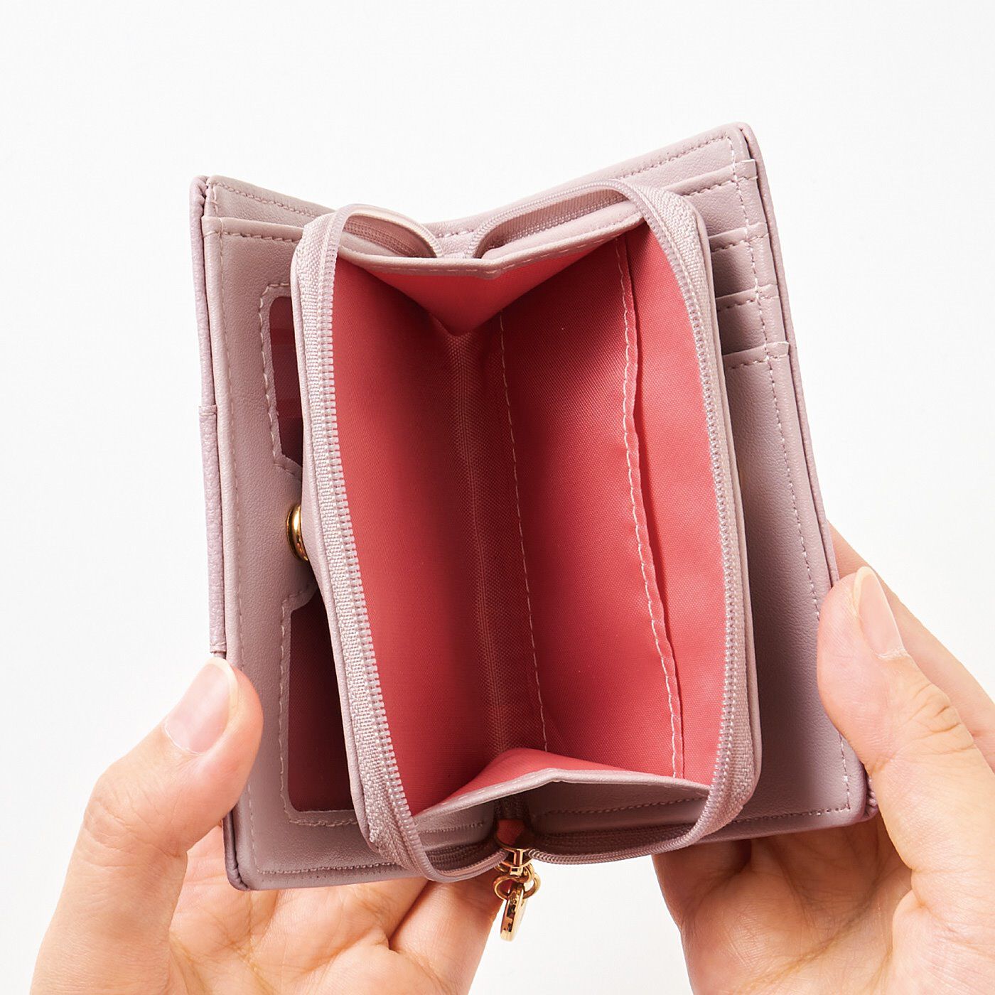 フェリシモの雑貨 Kraso|大人さくら色に心躍る　透明ポケットがついた二つ折り財布|二つ折りの真ん中に小銭入れを配置。お財布を開けなくても小銭を取り出せます。