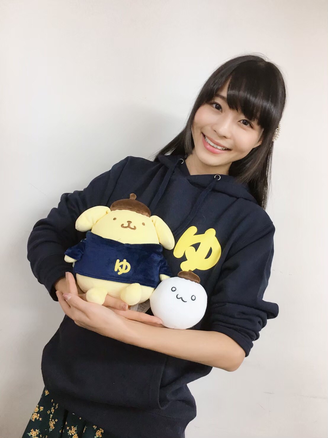 ポムポムプリンと、自身のオリジナルキャラ「だいふく」のコラボぬいぐるみを抱き抱える寺嶋さん